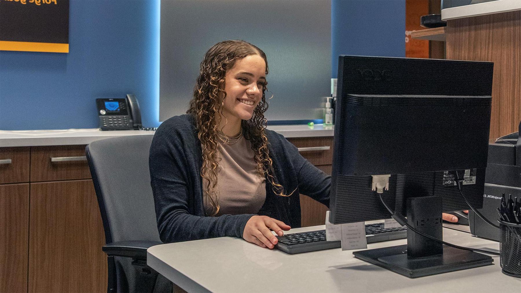 A student working at the bank on campus.